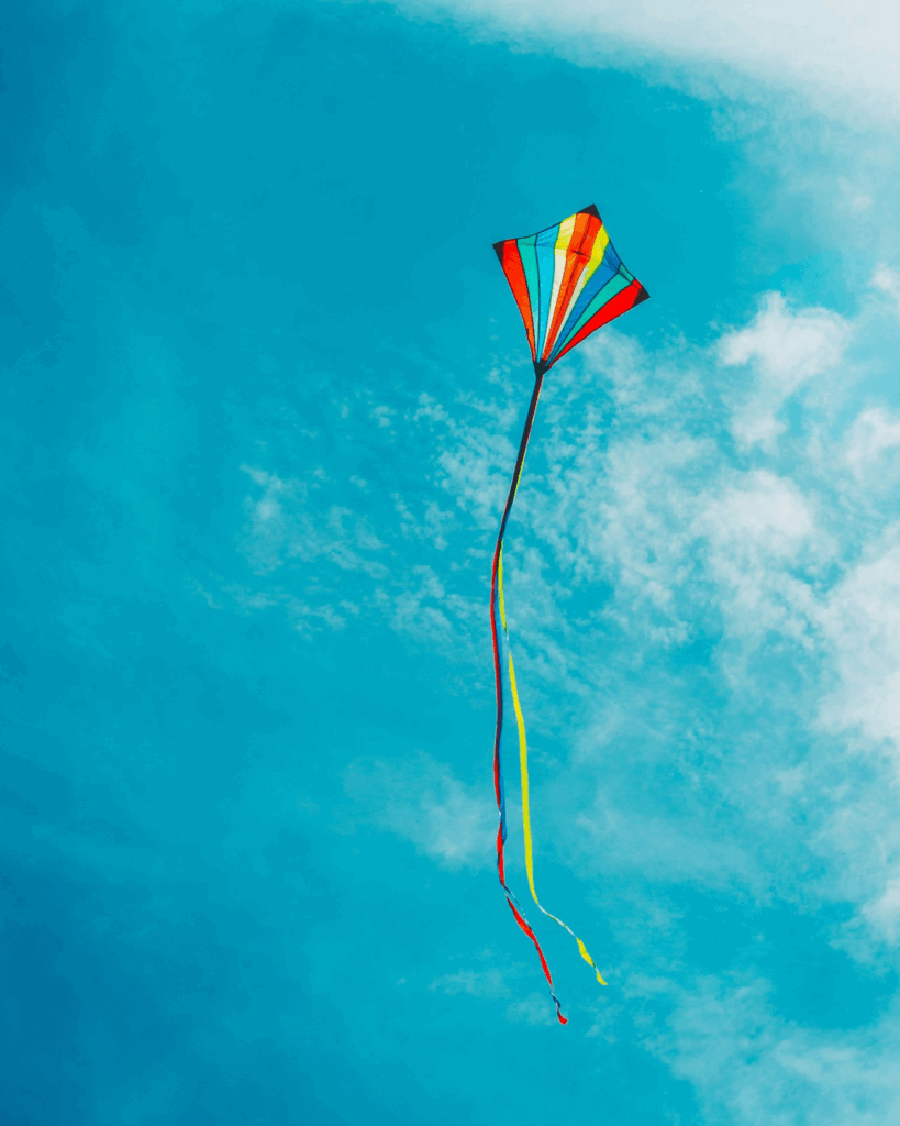 ein gute-Laune-Foto eines bunten Kinderdrachens in einem strahlend blauen Himmel  